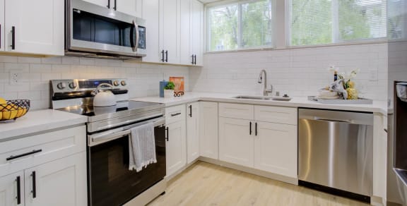 a kitchen with white cabinets and stainless steel appliances