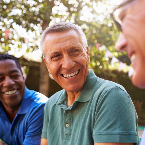 a group of men sitting in a park