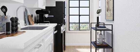 A black refrigerator in a kitchen with white cabinets.