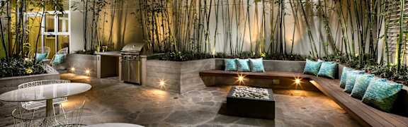 A modern outdoor seating area with a stone floor and a wall of hanging plants.at Chelsea Santa Monica, California, 90411