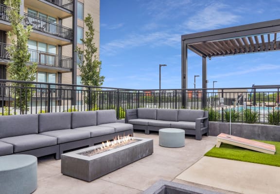 an outdoor patio with couches and a fire pit