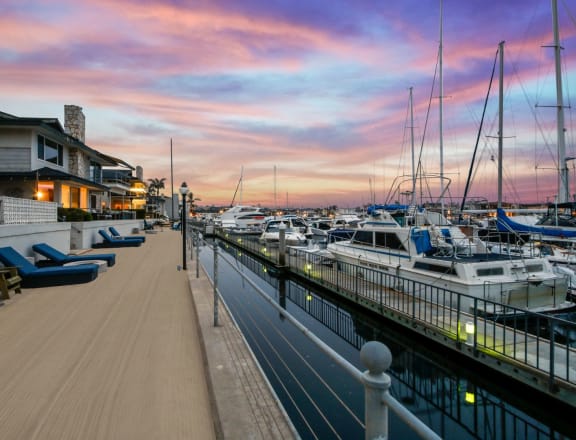 a marina at sunset with boats in the water and a house on the side of the