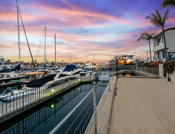 a marina with boats and yachts at sunset