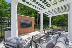 a covered patio with couches and a television