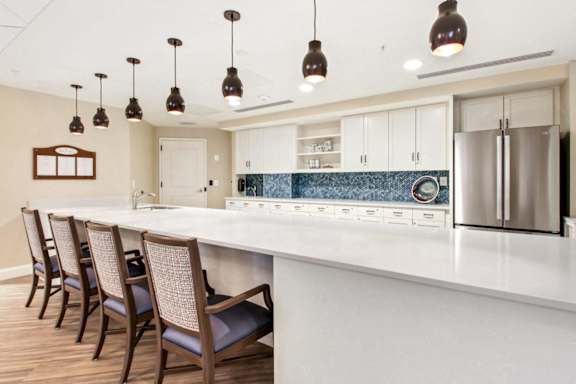 a kitchen with a large white counter top and chairs at White Springs Senior Living, Virginia 20186