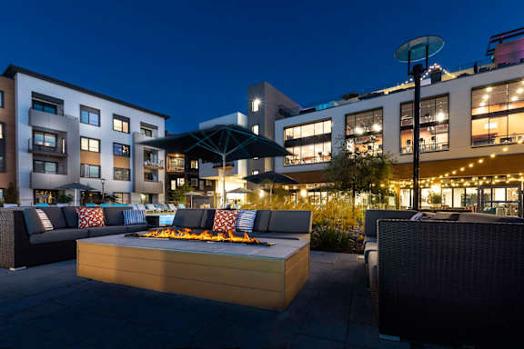A patio with a fire pit and seating area.
