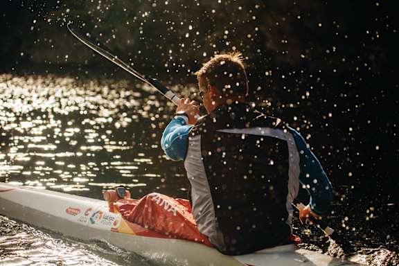 a man is paddling a kayak on the water