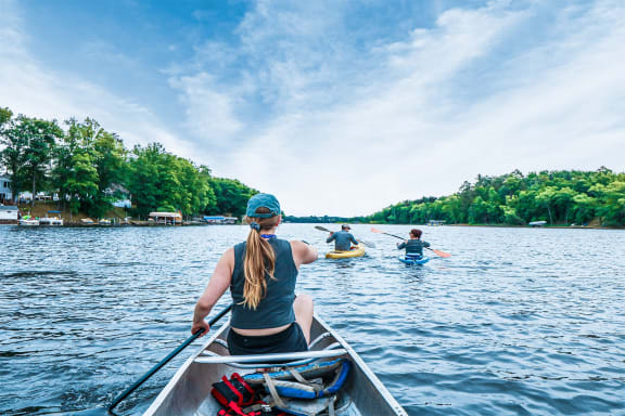 a group of people paddling a canoe on a lake