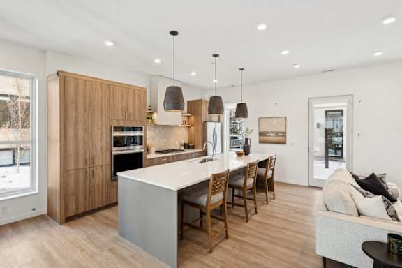 A modern kitchen with wooden cabinets and a white island.