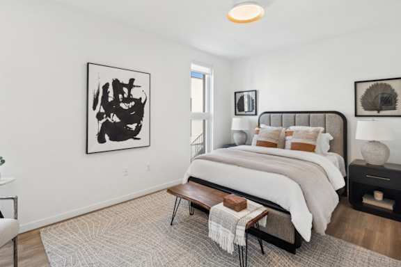 A bedroom with a large bed and a painting on the wall.