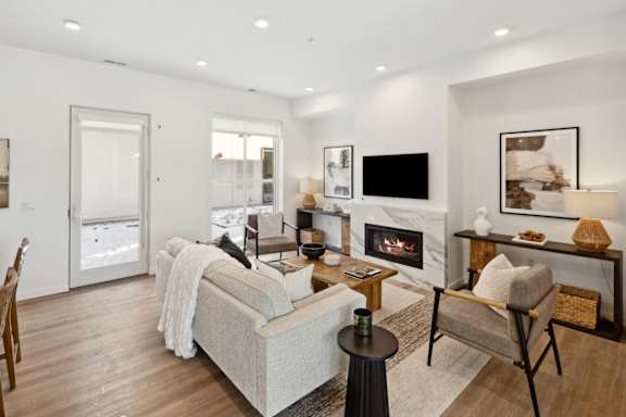 A modern living room with a fireplace and a grey couch.