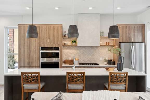A modern kitchen with wooden cabinets and a white island.