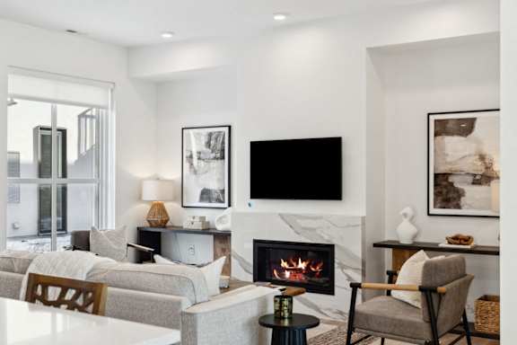 A modern living room with a fireplace and a flat screen TV.