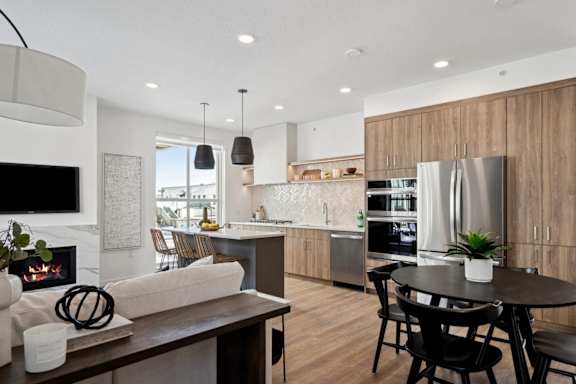 A modern kitchen with a dining table and chairs.