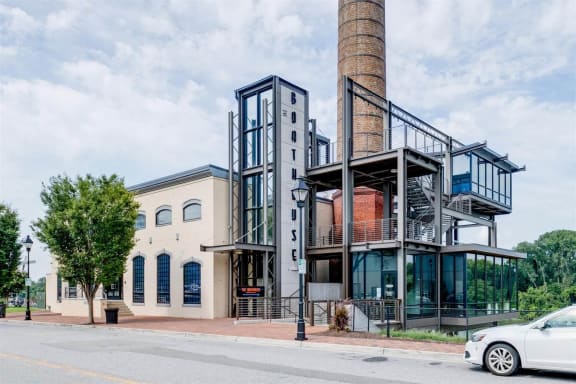 a building with a factory chimney on the side of a street at East 51 At Rocketts Landing, Richmond, 23231