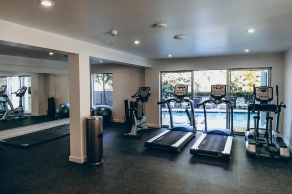 Brand New Fitness Center including treadmill, stationary bike, yoga with a pool view