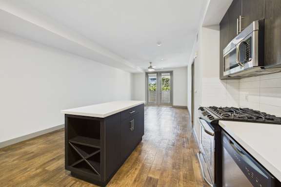 A kitchen with a black cabinet and a white countertop.