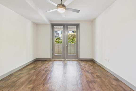 A room with a wooden floor and a ceiling fan.