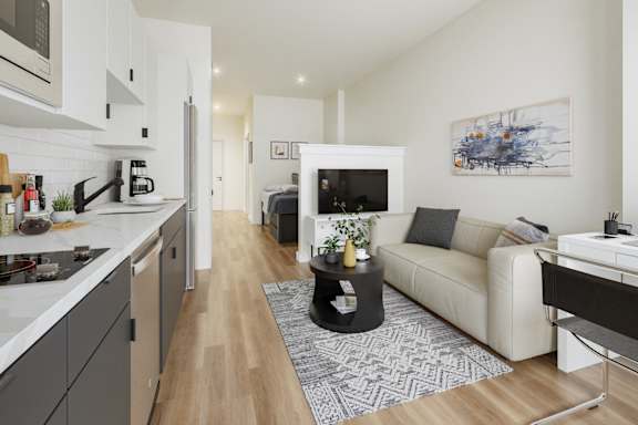 A modern kitchen with a white countertop and a white sofa in the living room.at Skylar At Sunset, Los Angeles