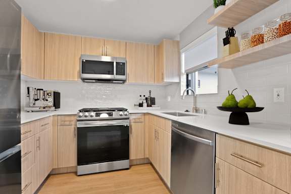 A modern kitchen with wooden cabinets and stainless steel appliances.