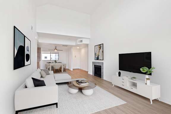 A modern living room with a white couch and a television.