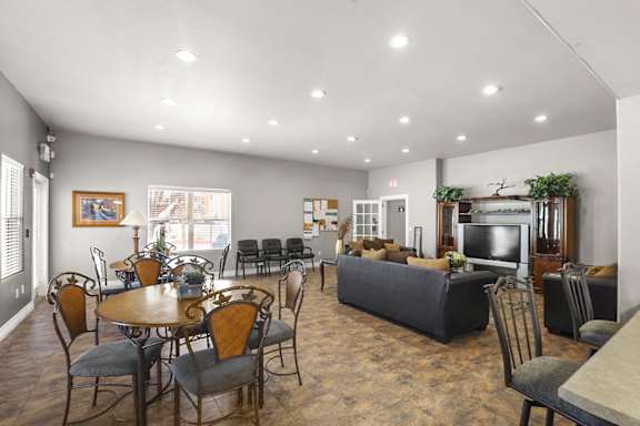 A spacious living room with a dining table and chairs.