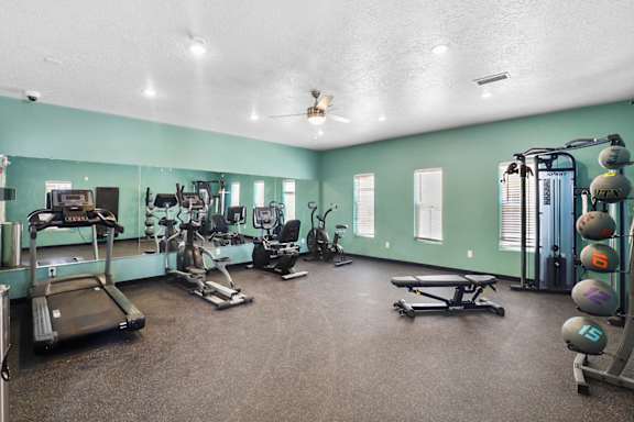 A spacious gym with a variety of equipment including treadmills, weights, and exercise machines.