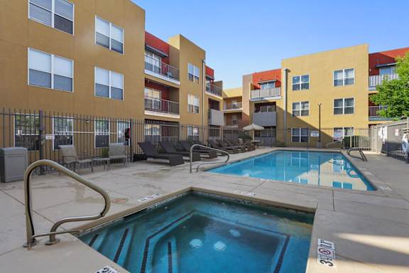 A swimming pool in front of apartment buildings.