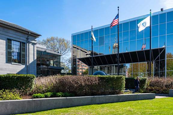A building with a glass facade and flags on top.