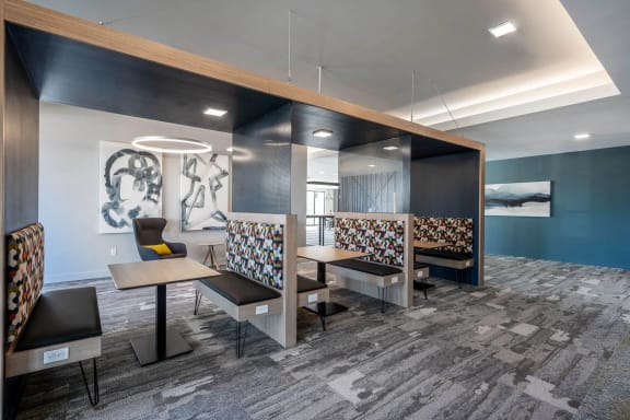 a seating area with tables and chairs in a lobby