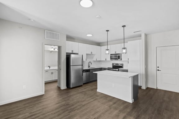 a kitchen with white cabinets and a stainless steel refrigerator