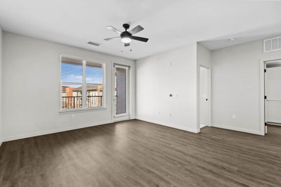an empty living room with a ceiling fan