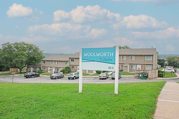A sign for Woolworth Estates stands in front of a building.