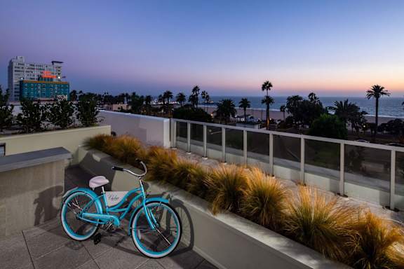 A blue bicycle is parked on a balcony overlooking the ocean.at Chelsea Santa Monica, California, 90411