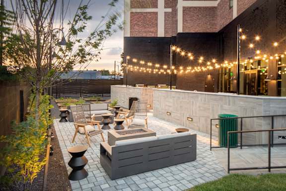 a patio with chairs and a table and a fire pit at The Irvine, Philadelphia