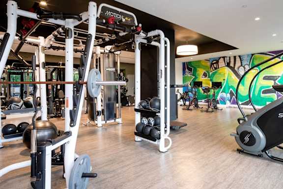 a gym with weights and a wall with graffiti at The Irvine, Philadelphia