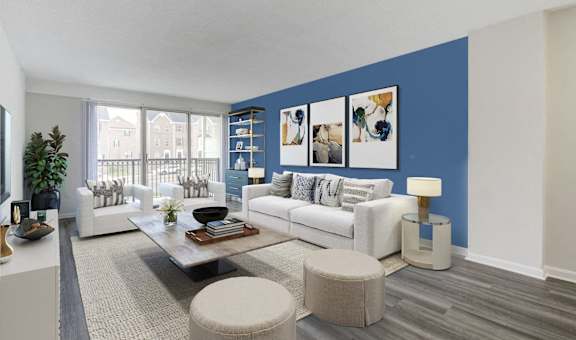 A living room with a white couch, a coffee table, and a large window.