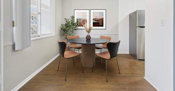 A dining room with a table and chairs.