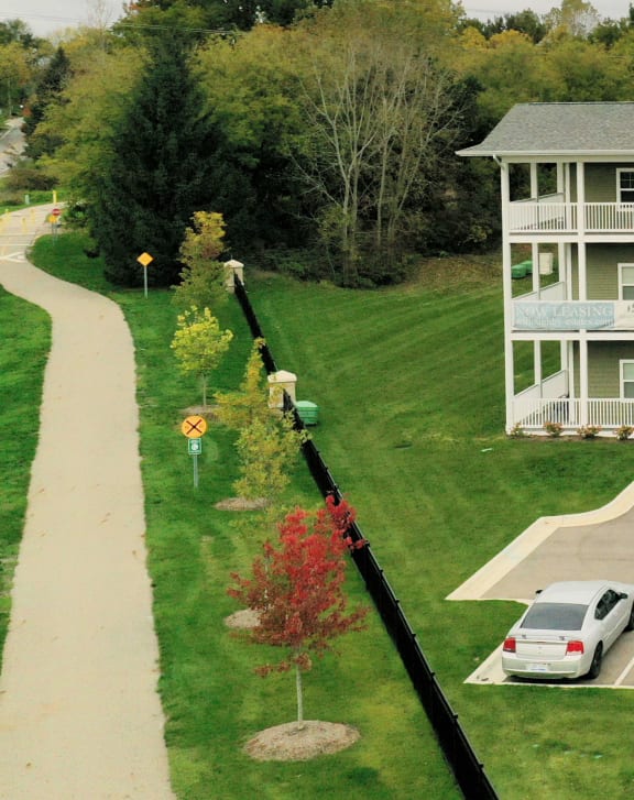 an aerial view of an apartment building and a car parked in a parking lot