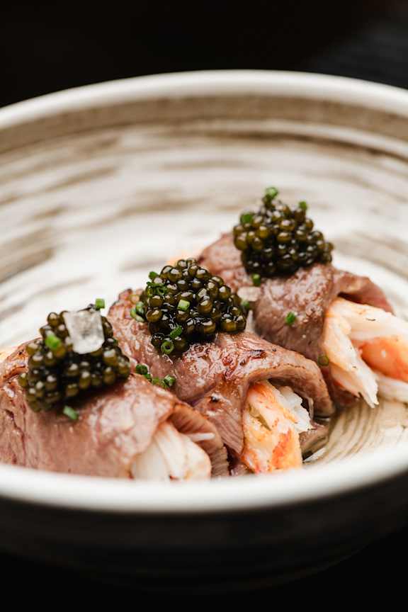 A dish with meat and caviar on top.