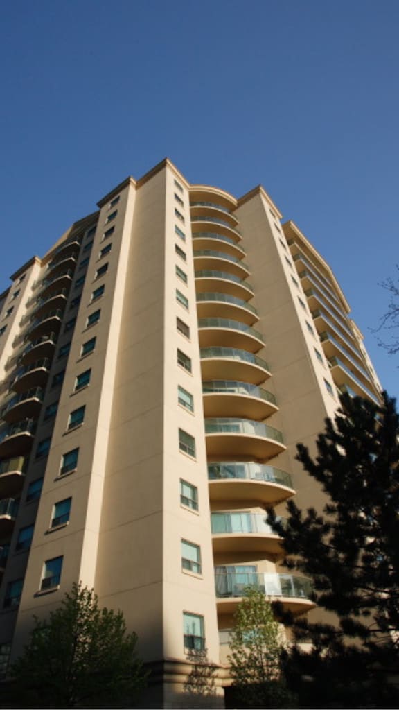 a large apartment building with many balconies and a car parked in front of it