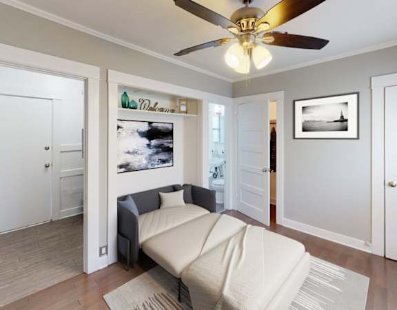 A living room with a couch and a ceiling fan.