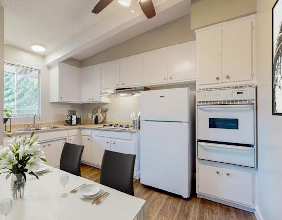 a white kitchen with white appliances and a white table
