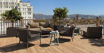 A patio with a table and chairs overlooking a cityscape.