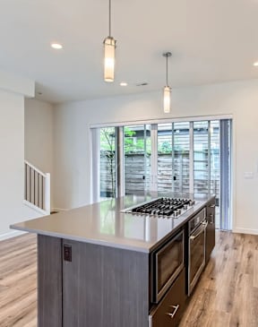A modern kitchen with dark wood cabinets and stainless steel appliances.