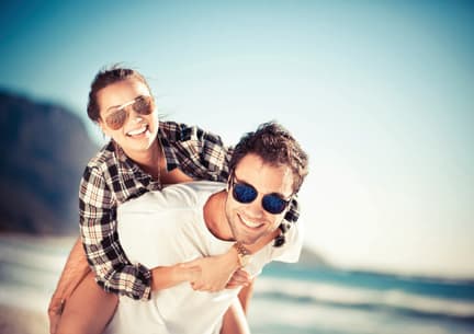 a man and a woman wearing sunglasses on the beach