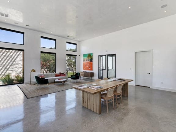 a large living room with a large wooden table and chairs
