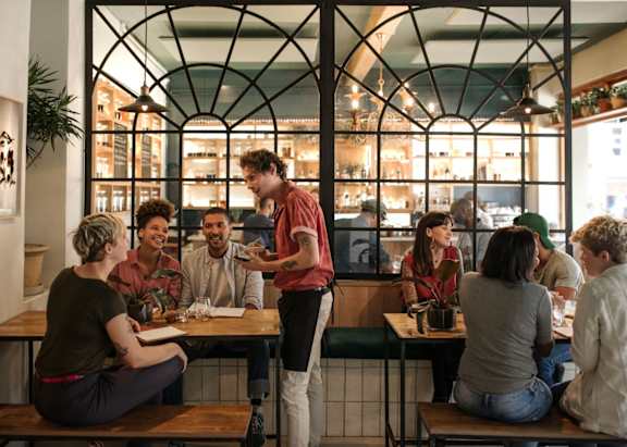 a group of people sitting at tables in a restaurant