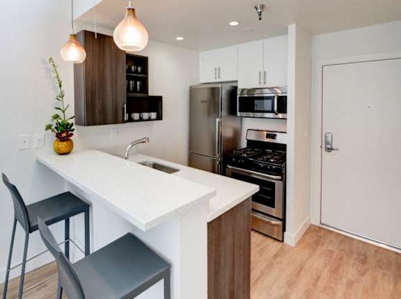 A kitchen with a white countertop and a refrigerator at 1022 Tiverton, Los Angeles, CA