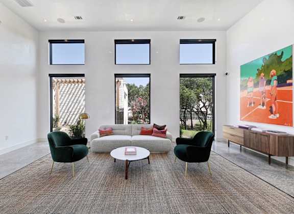 a living room with a couch and two chairs and a table